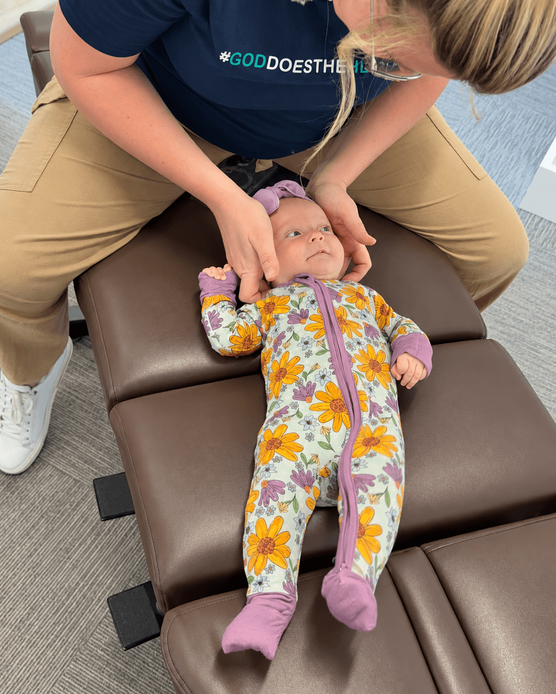 Dr. Ellen supporting an infant’s head during a pediatric chiropractic visit