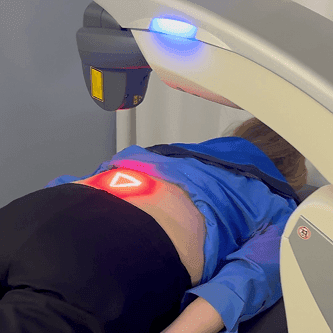 MLS laser positioned over a patient’s lower back during treatment