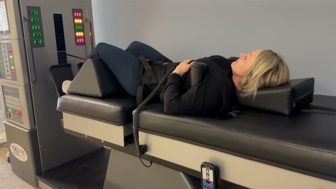 Hendersonville patient lying on the lumbar decompression table with a fitted harness and knee supports