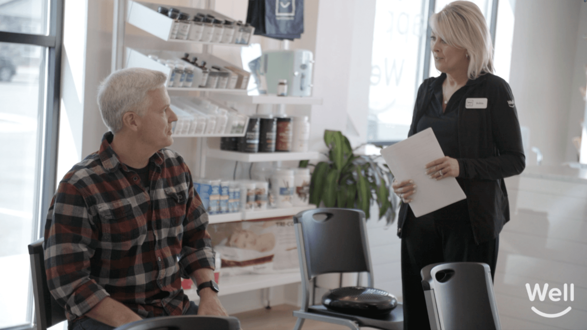 A Well team member talking with a patient before his visit