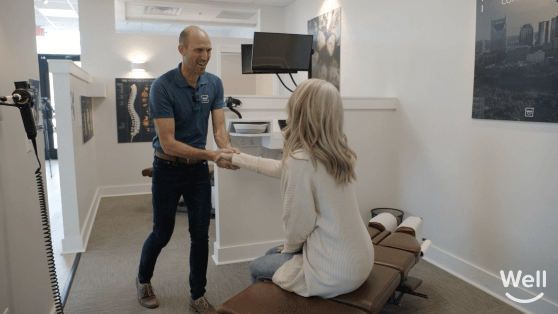 A smiling Well doctor greeting a patient with a handshake
