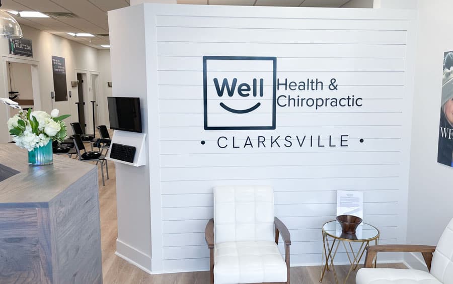 White chairs and Well Health & Chiropractic Clarksville sign in the reception area