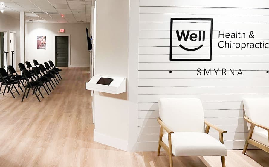 White reception chairs and Well Health & Chiropractic Smyrna sign