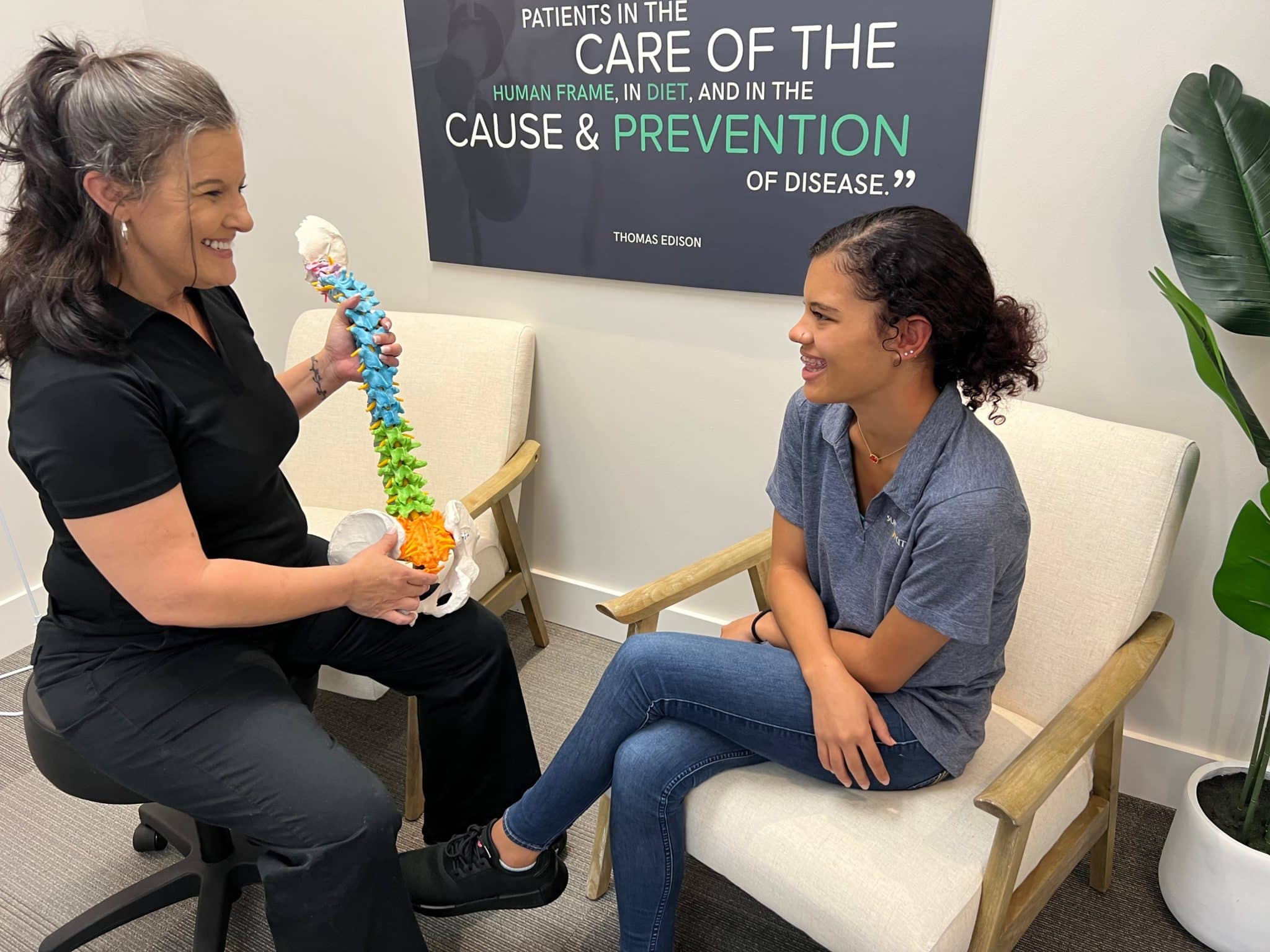 A team member explaining a spine model to a patient.