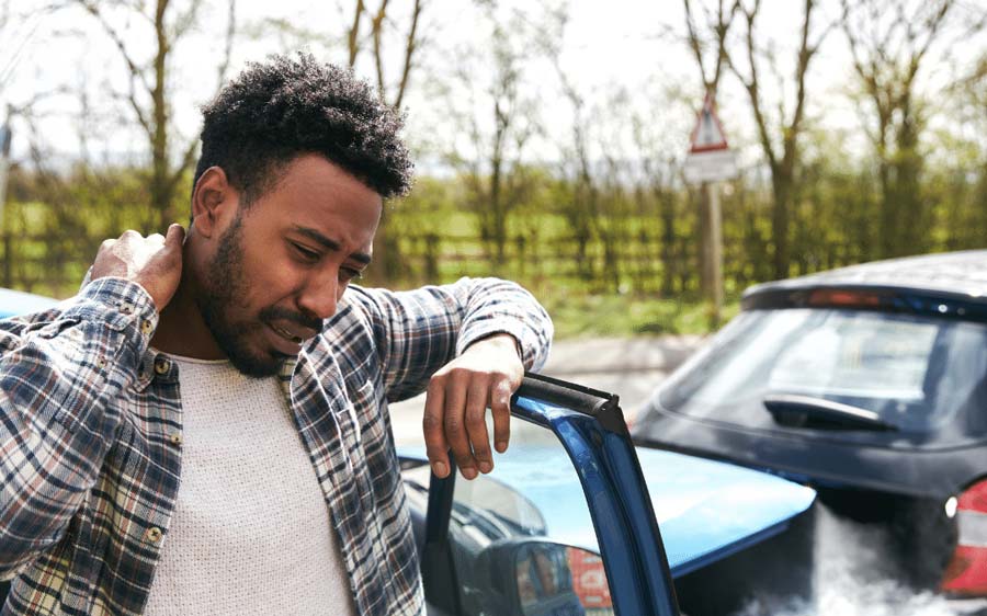Man with whiplash clutching his painful neck